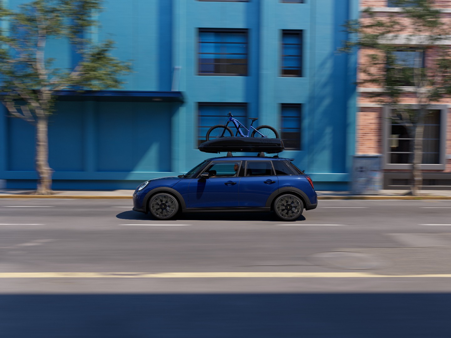Front view of MINI Aceman in Indigo Sunset Blue with MINI Roof Bike Rack, carrying a mountain bike and MINI Roof Box 320.